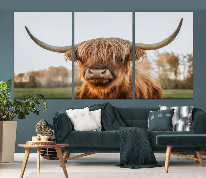 A Highland Cow Animal Scottish Cattle Art Print Farmhouse Wall Art Canvas Print hangs in the living room, adding a touch of rustic farmhouse decor.