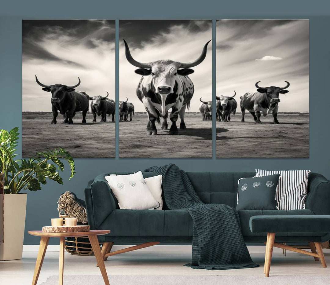 The Black and White Longhorn Cattle Wall Art, featuring a three-panel display of cowboy Western longhorns walking toward the viewer, enhances your space with its striking presence, adding a touch of Western decor.