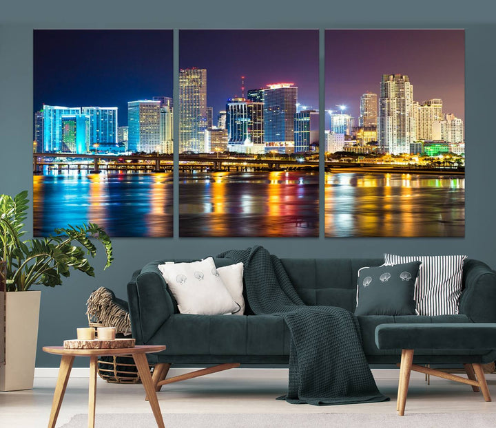 The Wall Art MIAMI Canvas Print features a stunning triptych of a city skyline at night, with vibrant lights reflecting on the water. This gallery-wrapped piece on museum-quality canvas delivers an exquisite finish.