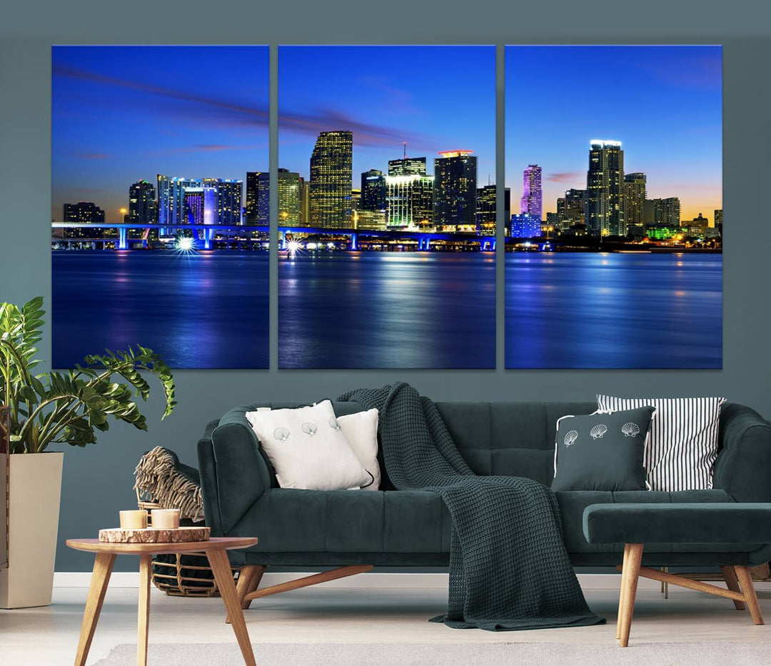 The modern living room showcases a striking Miami Blue Night Wall Art canvas print on the wall. The artwork is gallery wrapped on museum-quality canvas, ensuring durability and elegance.