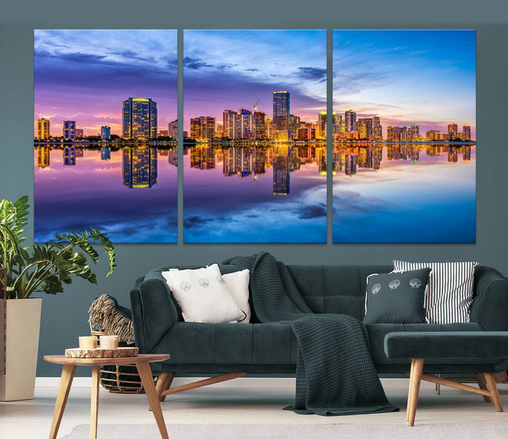 The Miami City Wall Art Canvas Print, featuring a three-panel depiction of a city skyline at sunset reflected in water, beautifully enhances the wall. Made with museum-quality canvas and a UV-protective coating, it comes ready to hang.