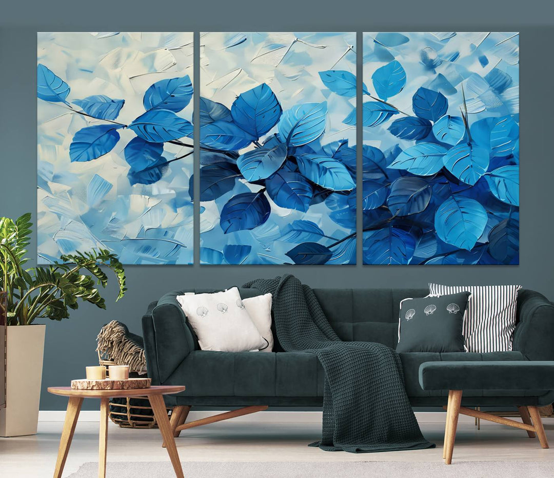 The contemporary living room is highlighted by the Abstract Blue Leaf Wall Art Canvas Print on the wall. The hand-assembled framed art enhances the room's vibrant decor, crafting a gallery-worthy ambience.