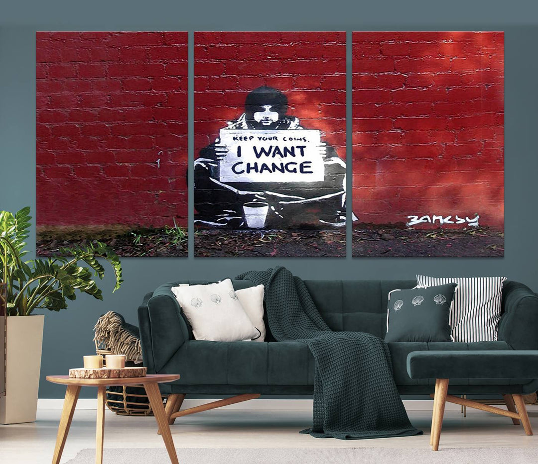 The living room showcases a triptych of stencil artwork on museum-quality canvas, featuring the Banksy I Want Change Graffiti Abstract Wall Art Canvas Print. This captivating piece depicts a person holding a sign that says "I want change" and is finished with a UV-protective coating to ensure long-lasting beauty.