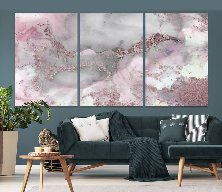 The Rose Marble Abstract Wall Art Canvas Print is a stunning triptych that showcases pink and gray tones, elegantly presented on a dark wall.