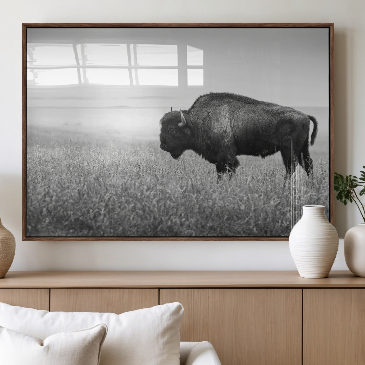 A black and white photograph of a majestic bison standing in a vast grassy prairie, evoking a sense of wilderness and strength.