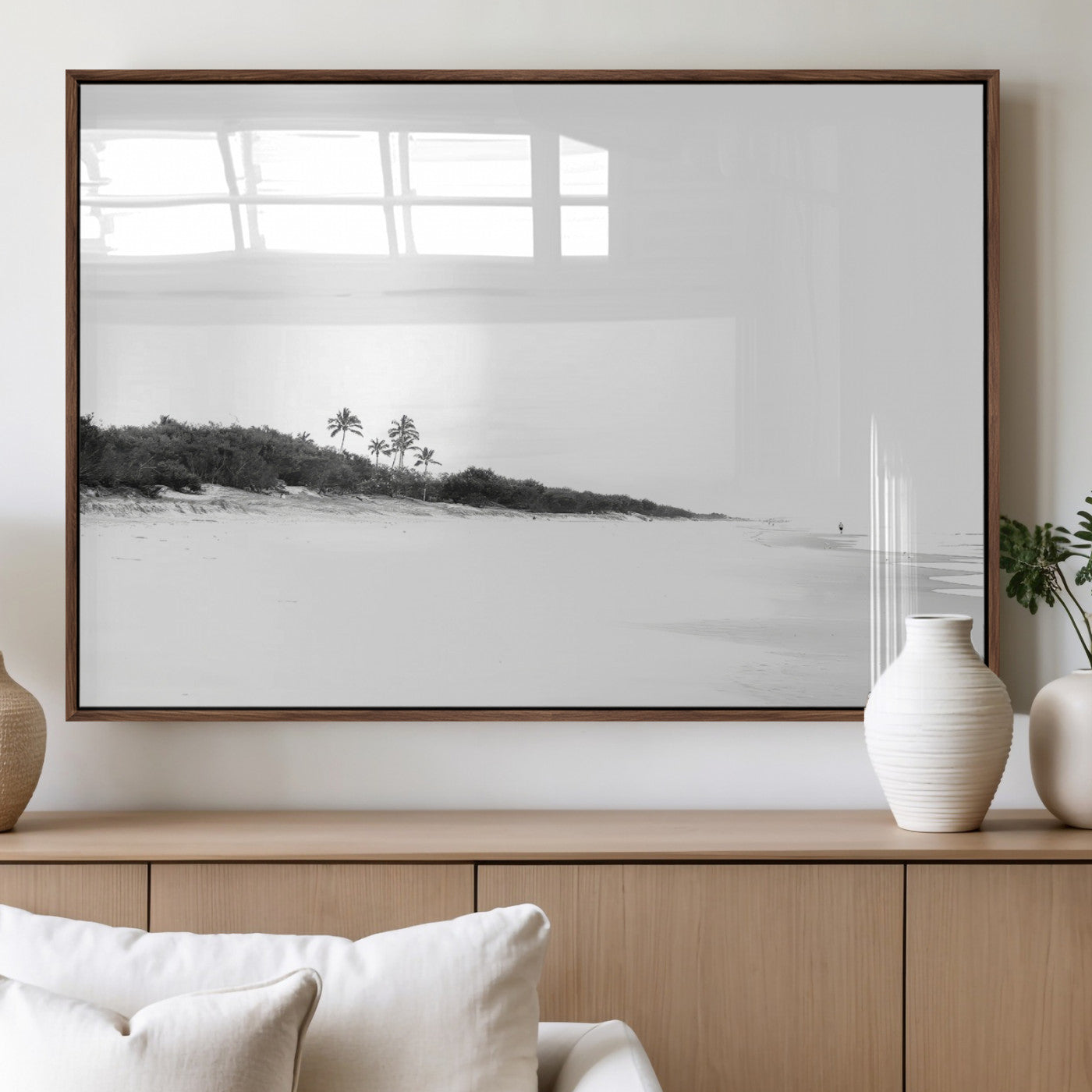 A black and white minimalist coastal scene with a vast open beach, distant palm trees, and a lone figure walking along the shoreline, evoking serenity and solitude.