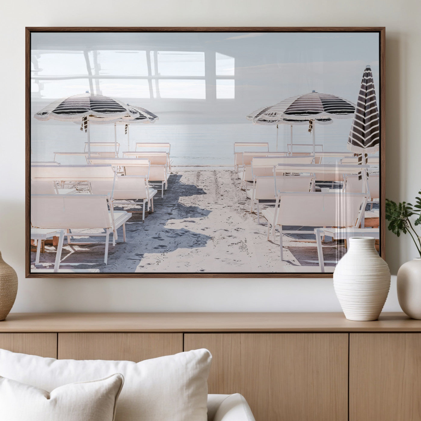 A serene minimalist beach scene featuring striped umbrellas, soft pastel sand, and an elegant lounge setup, creating a tranquil and stylish coastal retreat.