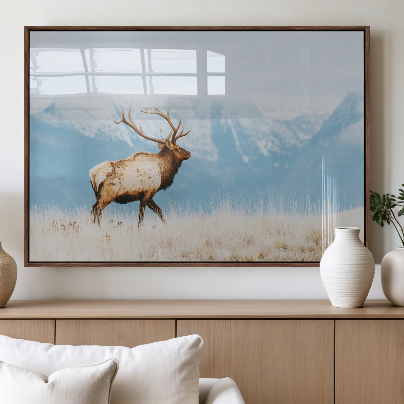 Majestic elk with antlers walking on golden grass, snowy mountains behind, perfect for rustic lodge or Scandinavian decor.