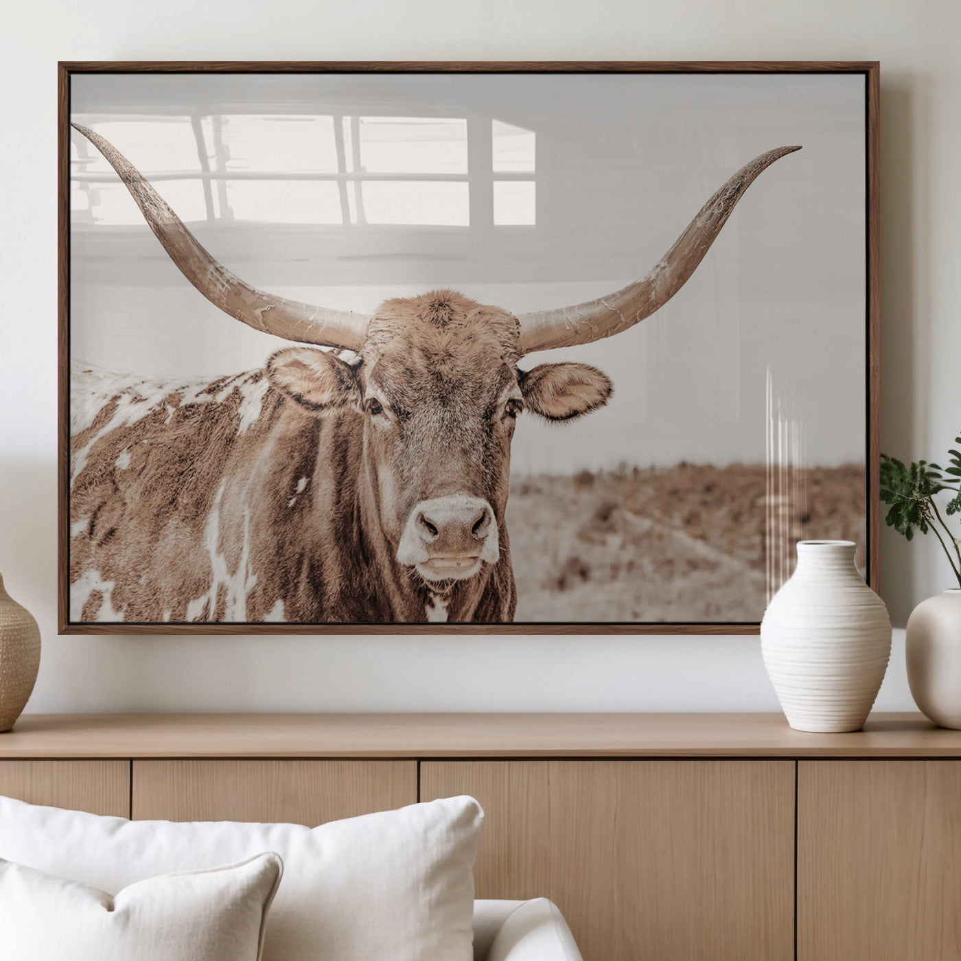 A longhorn cow in soft beige desert tones, standing calmly in open land, perfect for neutral western or rustic farmhouse interiors.