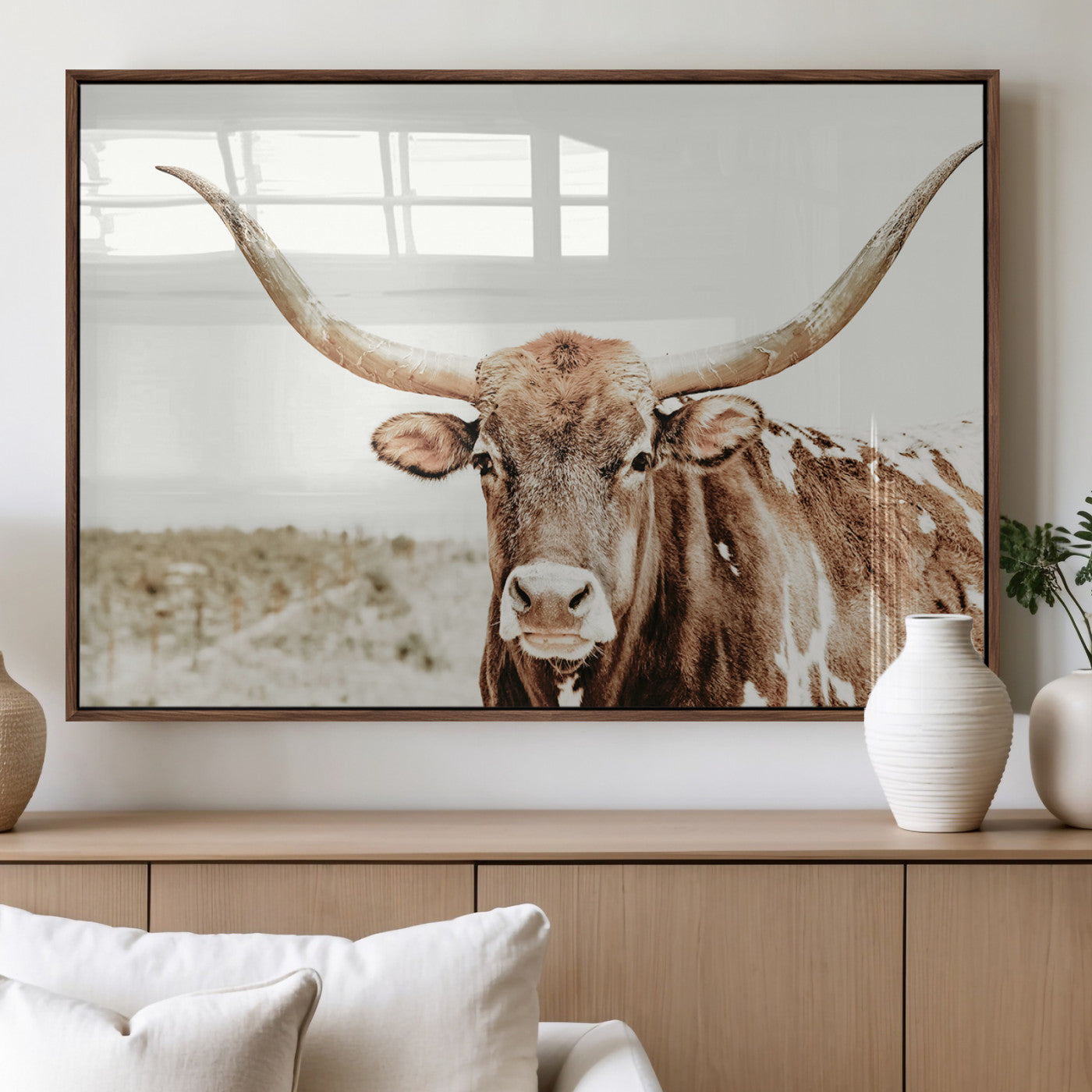 A Texas longhorn bull with wide horns, standing in a dry field under soft light, ideal for rustic farmhouse or western-themed interiors.
