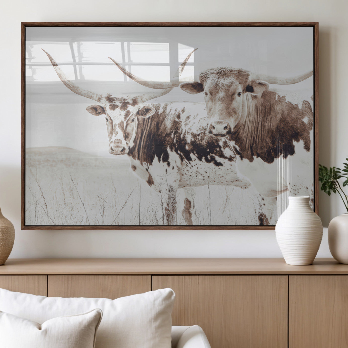 Two longhorn cattle standing in a dry grassy field with neutral tones, creating a rustic and farmhouse-inspired Western aesthetic.
