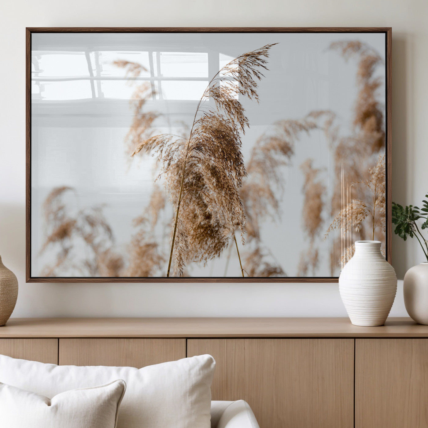 Close-up of pampas grass swaying in the wind against a soft white sky, creating a neutral and minimalist botanical aesthetic.