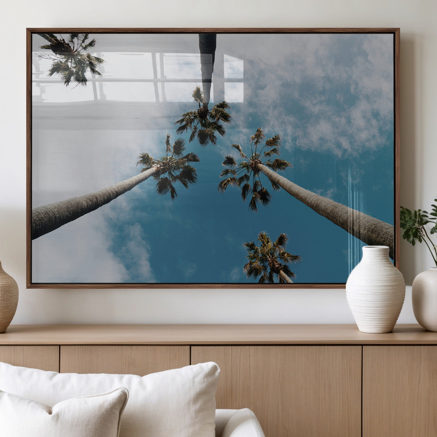 Looking up at tall palm trees against a bright blue sky with scattered clouds, creating a tropical and airy atmosphere for modern home decor.
