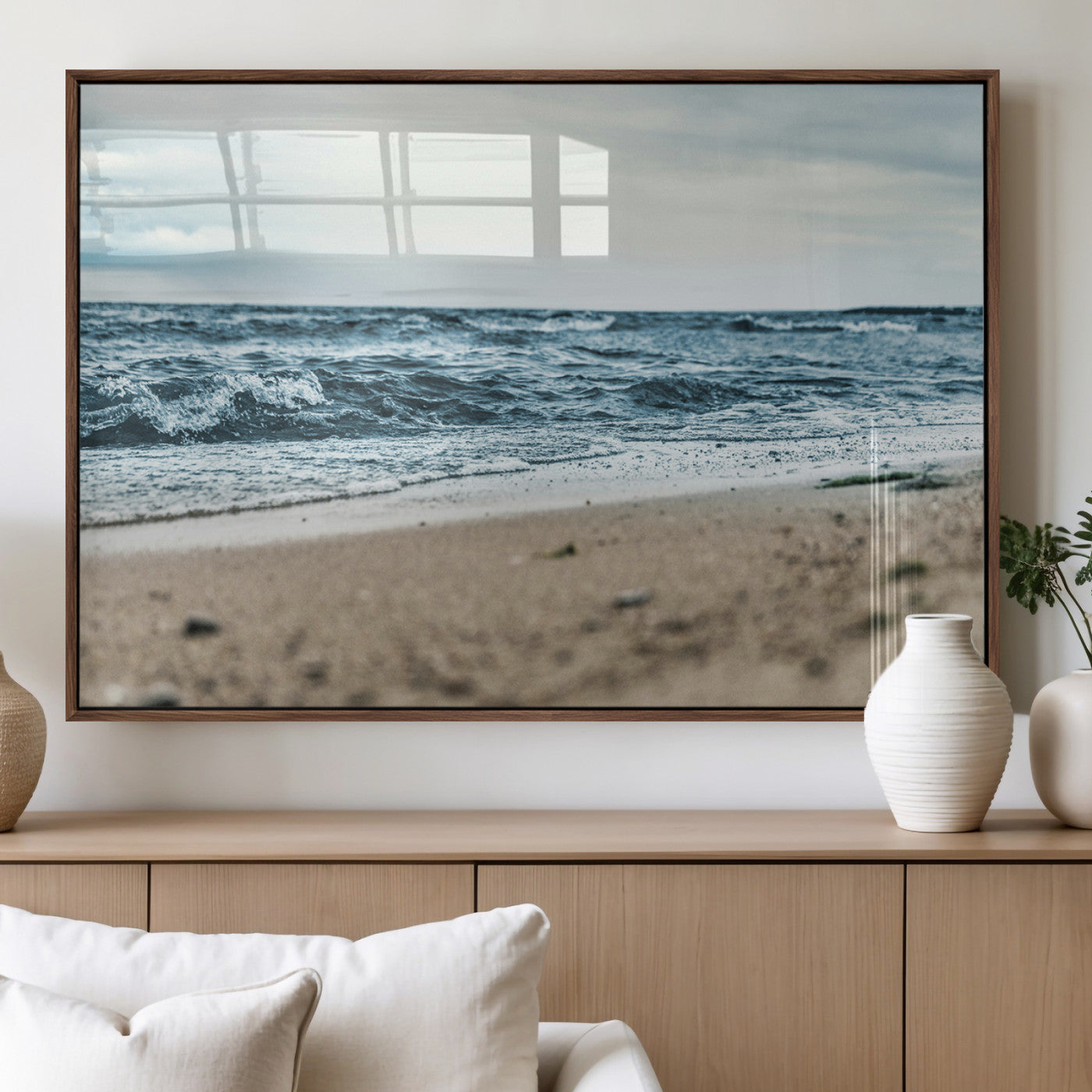 A moody ocean scene with gentle waves washing onto a sandy beach under a cloudy sky, creating a peaceful and coastal atmosphere.