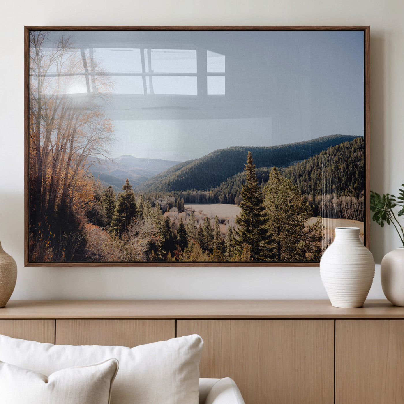 A scenic mountain valley with pine trees and autumn foliage under a clear sky, bathed in golden sunlight, creating a peaceful and rustic landscape.