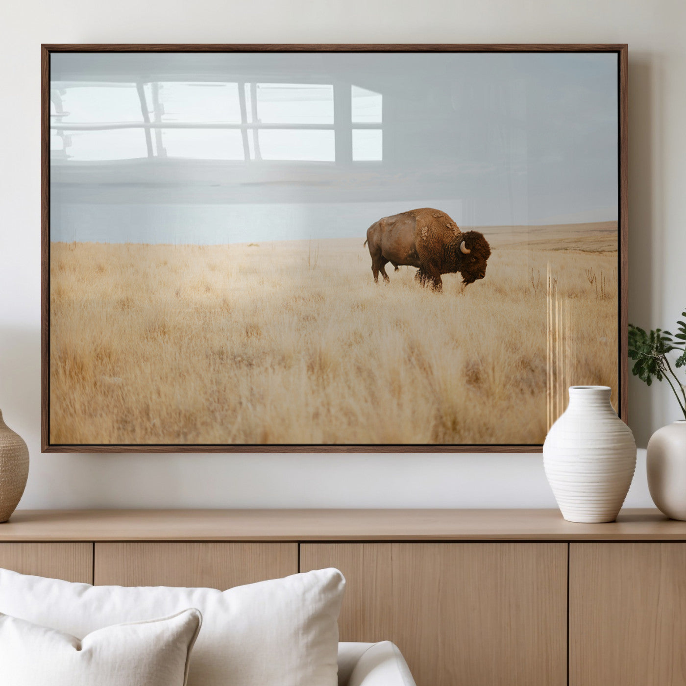 A lone bison standing in a vast golden grassland under a soft blue sky, evoking a rustic and Western aesthetic, ideal for farmhouse decor.