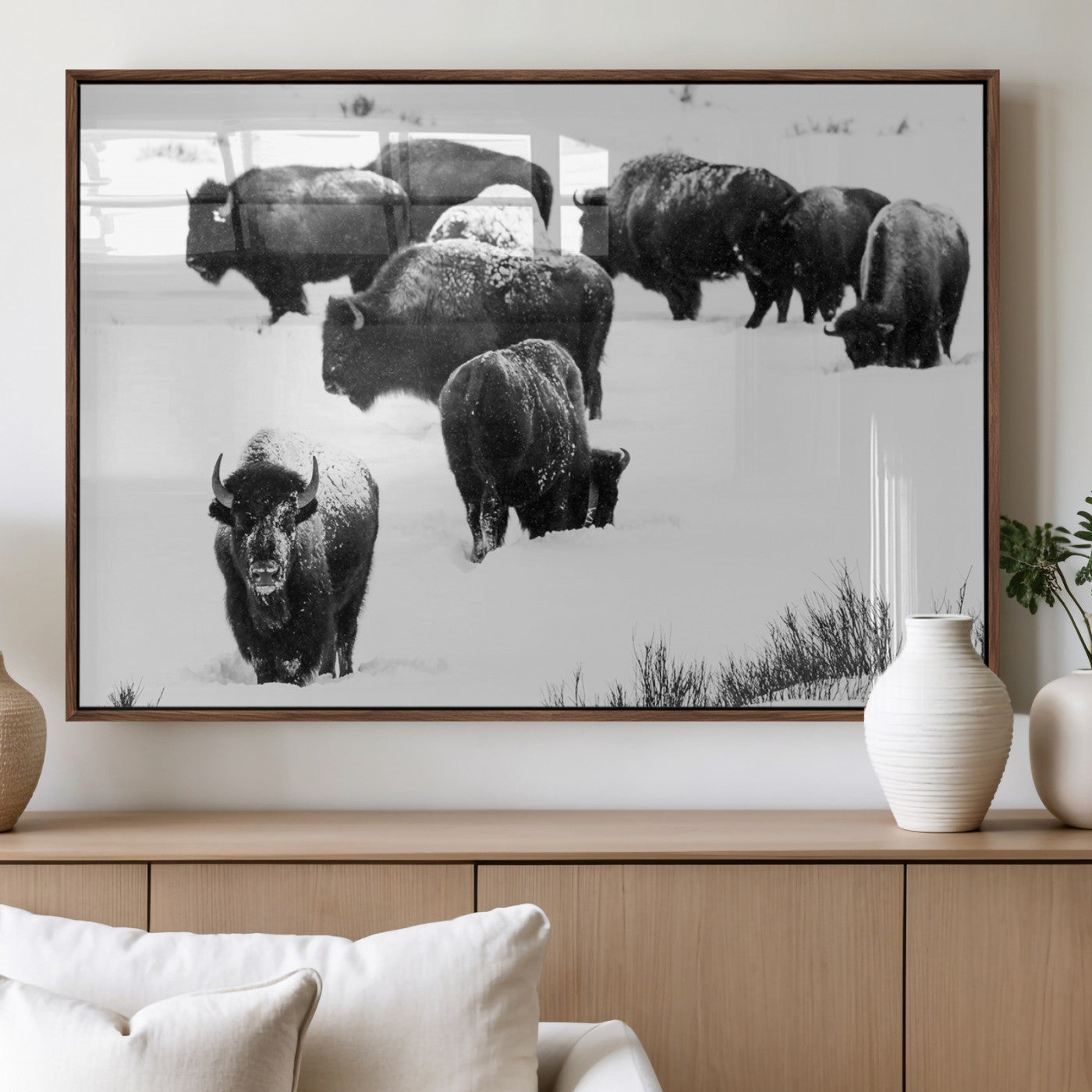 Black and white photograph of a bison herd in a snowy landscape, with snow-covered fur and a rugged wilderness setting, perfect for rustic lodge decor.