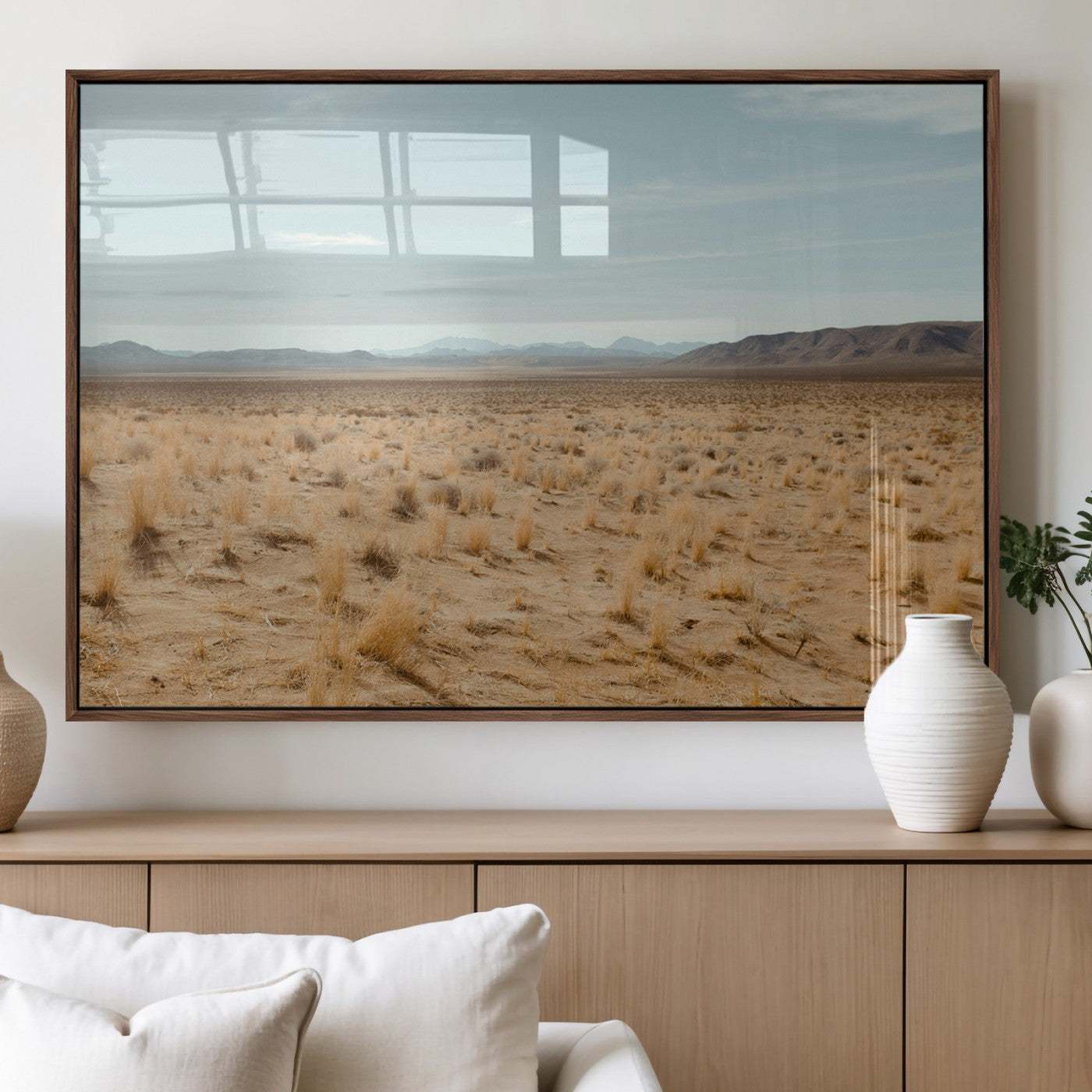 Expansive desert landscape with scattered dry grass and distant mountain range under a pale blue sky – Wall Art Canvas Print.