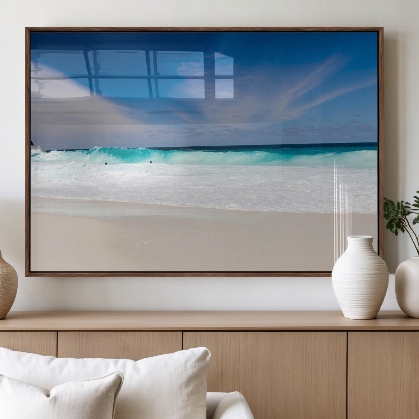 Turquoise waves crash onto a pristine white sand beach under a vivid blue sky with wispy clouds, creating a peaceful and refreshing coastal scene.