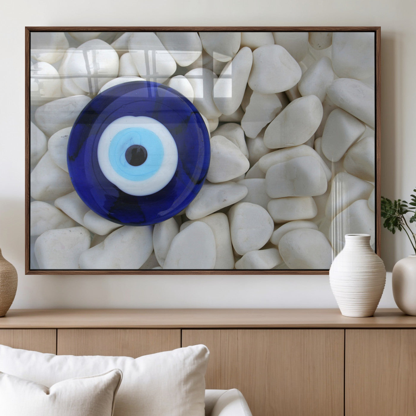 A close-up of a blue evil eye charm placed on white pebbles, symbolizing protection and good luck.