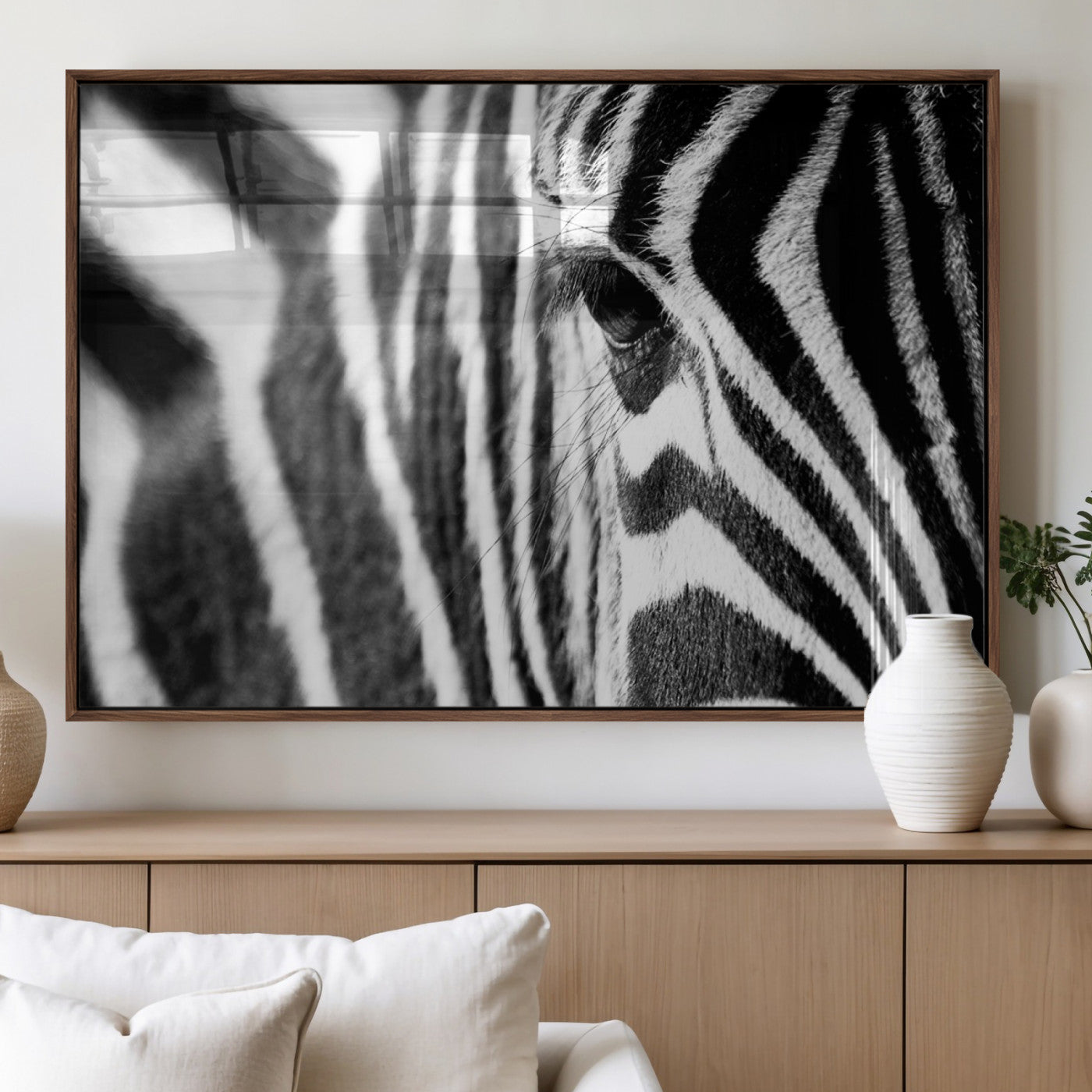 A close-up black and white photograph of a zebra's eye, showcasing the intricate patterns of its stripes in sharp detail.