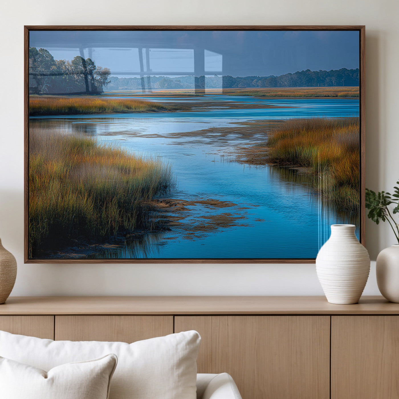 A peaceful marshland scene with calm blue water reflecting the surrounding grasses and trees, capturing the beauty of nature in a serene landscape.