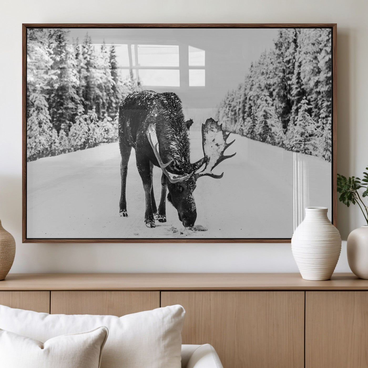 A majestic moose grazing in the snow-covered wilderness, surrounded by snow-covered trees, creating a peaceful winter scene.