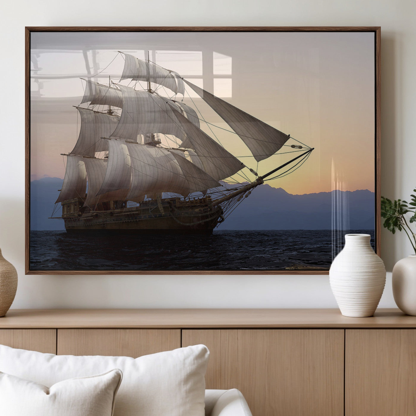 Majestic tall ship with full sails gliding across the ocean at sunset, with mountain silhouettes in the background – Wall Art Canvas Print.