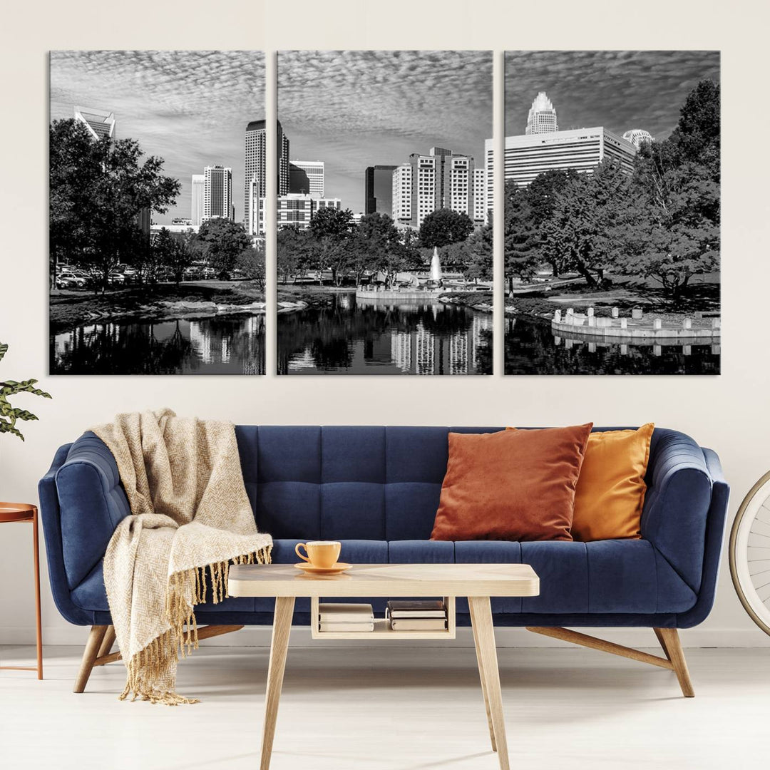 The living room features a captivating triptych titled "Charlotte City Cloudy Skyline Black and White Wall Art Cityscape Canvas Print," crafted on museum-quality canvas with UV-protective coating. Modern decor accentuates the dynamic scene.