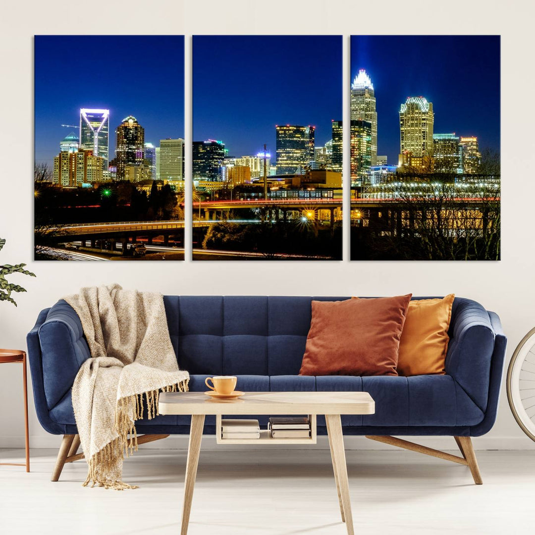 The Charlotte City Lights Night Blue Skyline Cityscape View Wall Art Canvas Print, showcasing an illuminated city skyline at night, is printed on museum-quality canvas with a UV-protective coating. Enhance your space with this stunning piece and enjoy free shipping with your purchase.