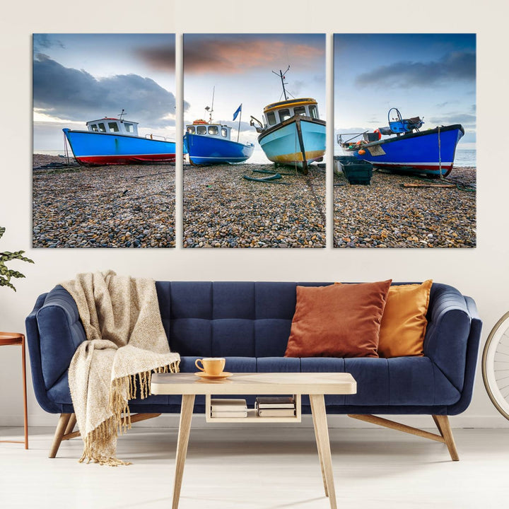 The "Big Boats On The Beach Wall Art Canvas Print" is a stunning piece featuring three museum-quality panels depicting fishing boats on a pebbled shore. Ready to hang and featuring UV-protective coating, it serves as an elegant addition to your home décor.