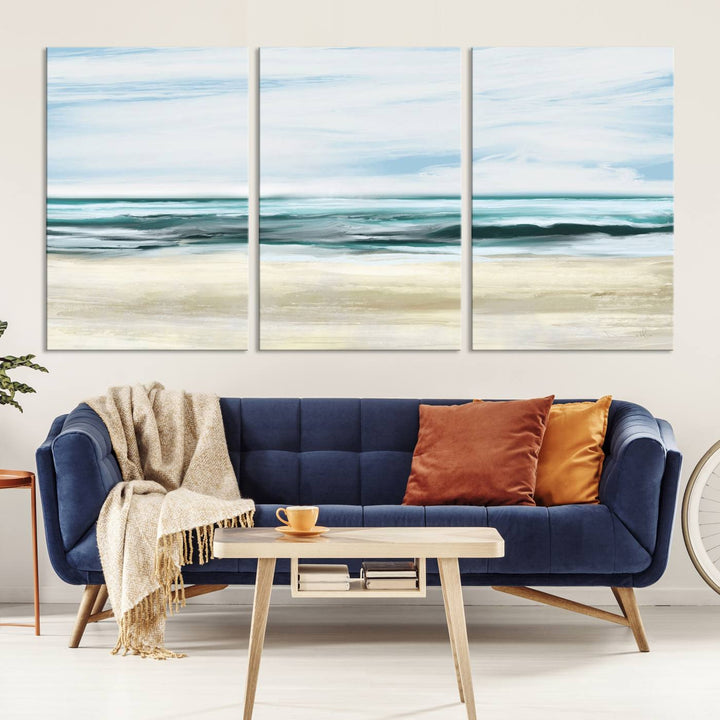 The room features the Ocean Abstract Wall Art Canvas Print, a triptych beach painting on museum-quality canvas with a gallery-wrapped finish and UV-protective coating.