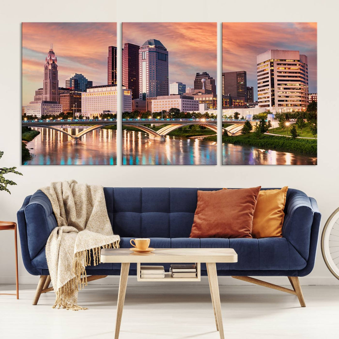 The "Columbus City Lights Sunset Orange Cloudy Skyline Cityscape View" wall art is featured on the wall. This triptych is printed on museum-quality canvas and includes a UV-protective coating, ensuring lasting vibrancy.