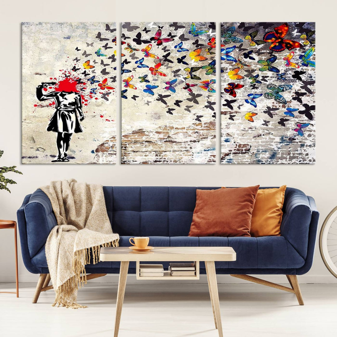 The Banksy Art Butterfly Girl Explosion Canvas showcases a dynamic figure with butterflies bursting from their head, set against a textured wall background. This vibrant urban graffiti piece is perfect for modern interiors and comes ready to hang.