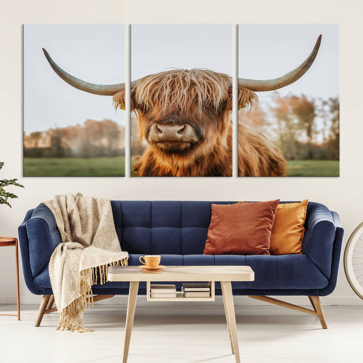 A Highland Cow Animal Scottish Cattle Art Print Farmhouse Wall Art Canvas Print hangs in the living room, adding a touch of rustic farmhouse decor.