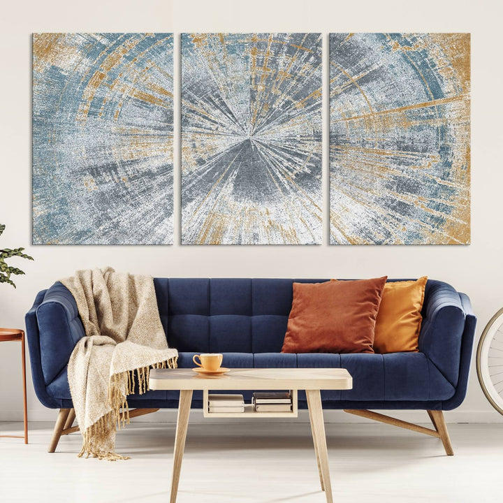 The Radiant Abstract Wood Rings Canvas Art, a modern triptych wall decor, enhances the contemporary style of the living room with its blue, white, and gold hues.