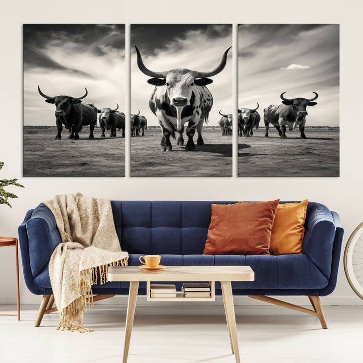 The Black and White Longhorn Cattle Wall Art, featuring a three-panel display of cowboy Western longhorns walking toward the viewer, enhances your space with its striking presence, adding a touch of Western decor.