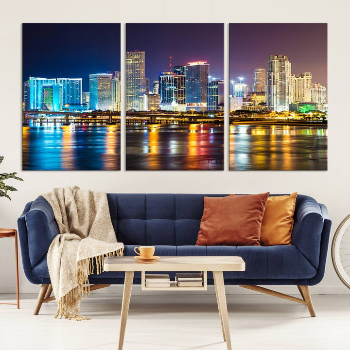 The Wall Art MIAMI Canvas Print features a stunning triptych of a city skyline at night, with vibrant lights reflecting on the water. This gallery-wrapped piece on museum-quality canvas delivers an exquisite finish.