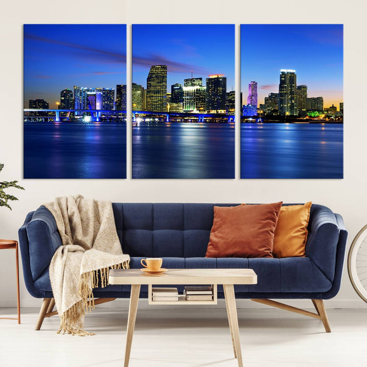 The modern living room showcases a striking Miami Blue Night Wall Art canvas print on the wall. The artwork is gallery wrapped on museum-quality canvas, ensuring durability and elegance.