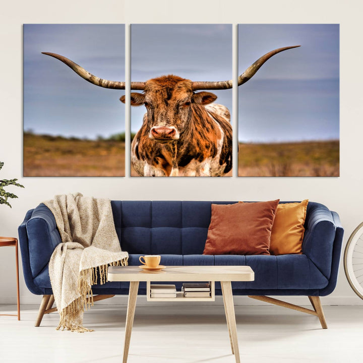 The Texas Longhorn Wall Art Print, a triptych canvas artwork depicting a longhorn bull in a field, features a gallery-quality finish.