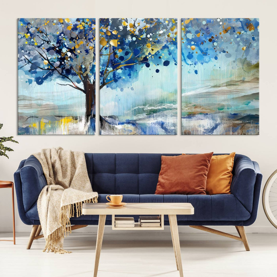 A modern living room features a three-panel Watercolor Style Abstract Tree Printing Wall Art Canvas in vibrant blue and yellow, crafted on museum-quality material.