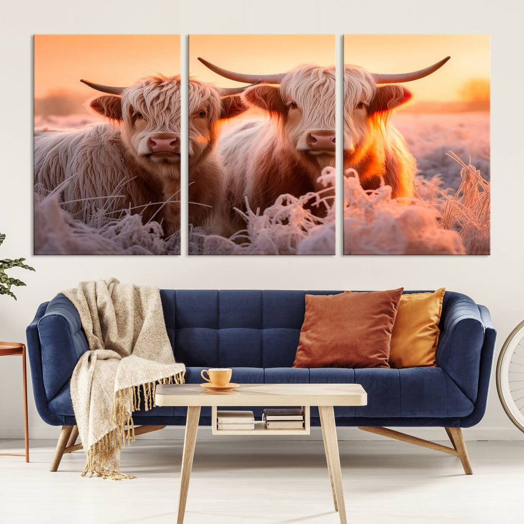 The "Highland Cows at Sunrise Wall Art Canvas Set" beautifully captures a serene and rustic farmhouse aesthetic, portraying two Highland cows in a frosty landscape at sunrise.