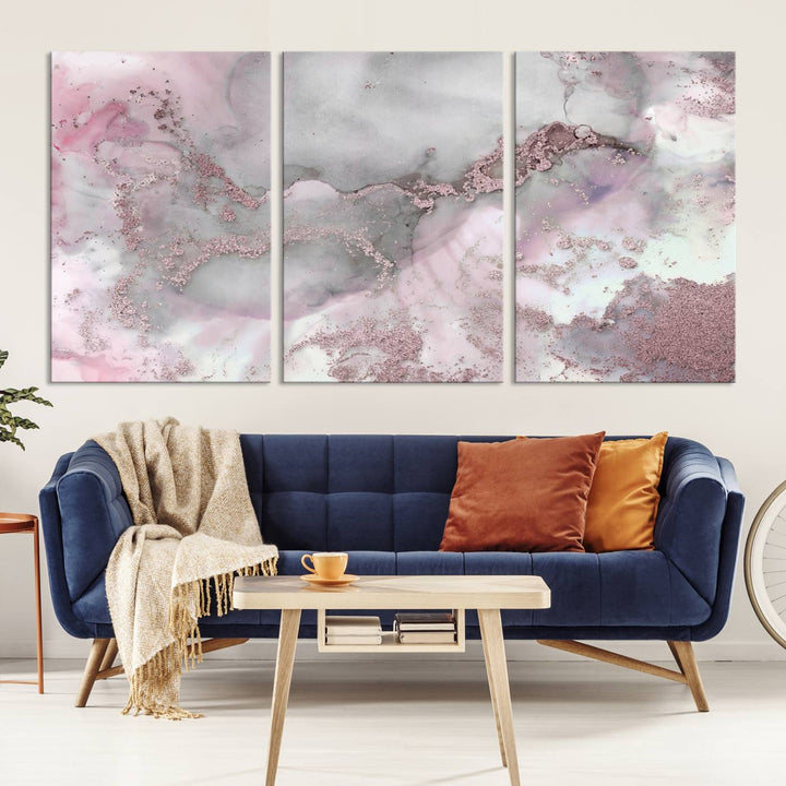 The Rose Marble Abstract Wall Art Canvas Print is a stunning triptych that showcases pink and gray tones, elegantly presented on a dark wall.