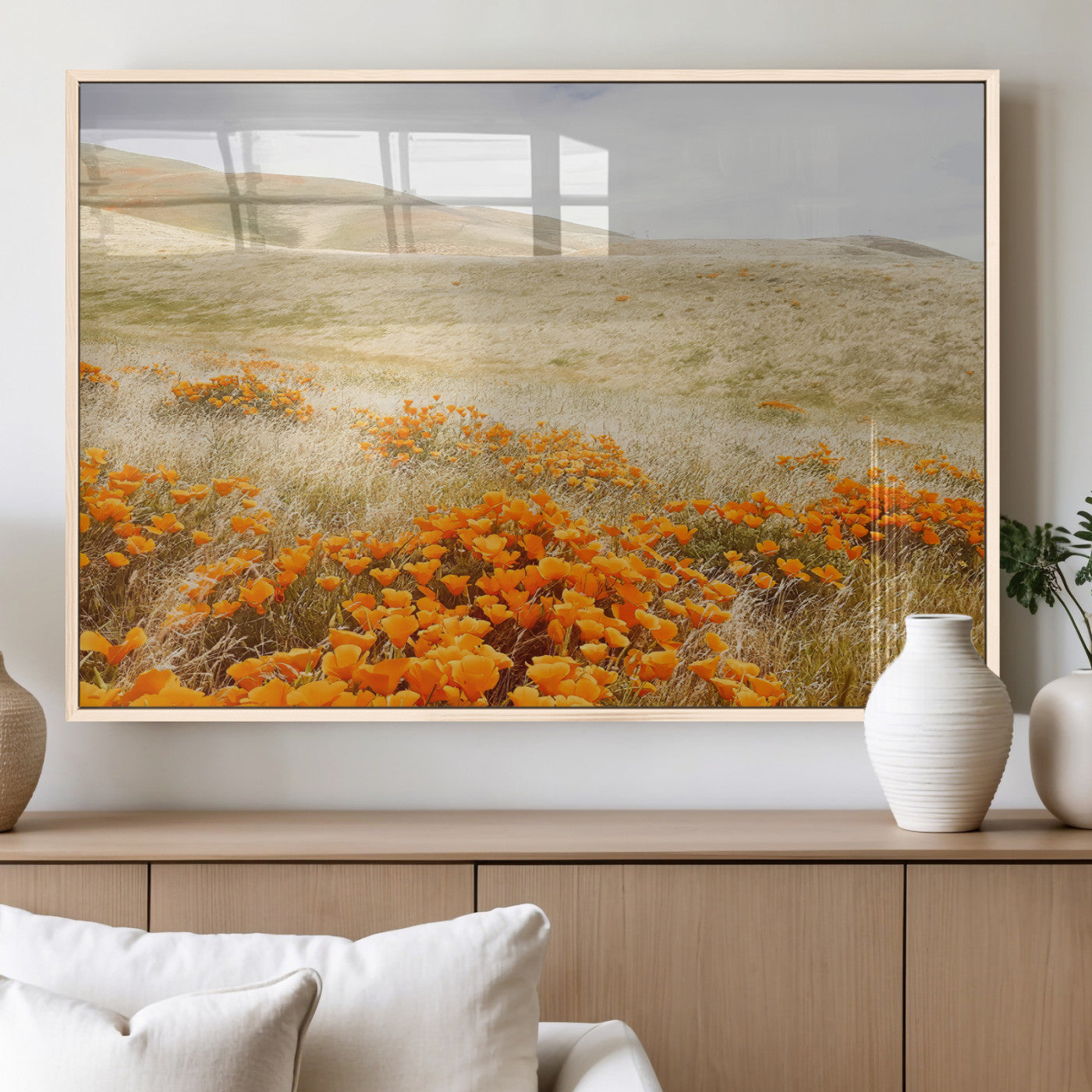A golden field with vibrant orange poppies blooming across rolling hills under a soft, sunlit sky, creating a warm and rustic landscape.