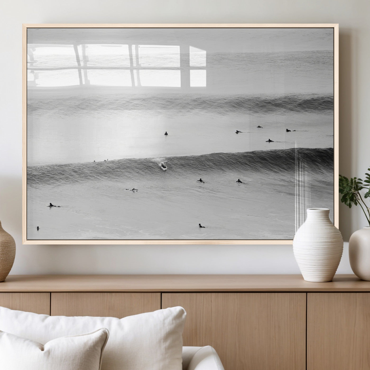 A monochrome photograph of swimmers gliding through gentle ocean waves, evoking a sense of calm and movement.
