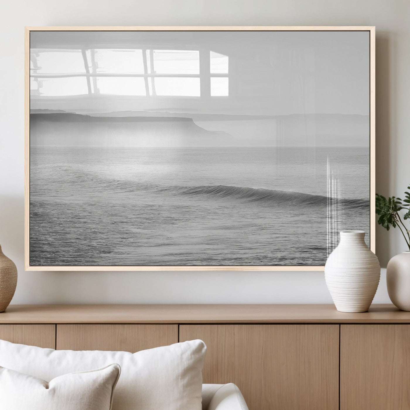 A black and white minimalist seascape featuring soft rolling waves and misty distant cliffs, creating a serene and timeless coastal atmosphere.