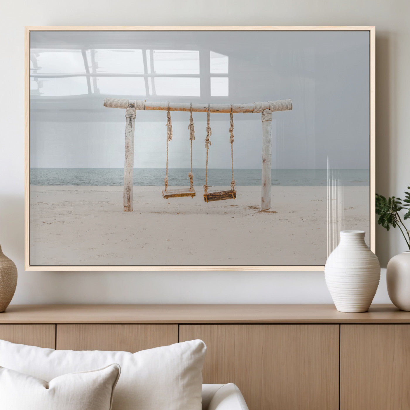 A rustic wooden beach swing stands on a serene sandy shore with an ocean horizon in the background, creating a tranquil and dreamy coastal escape.