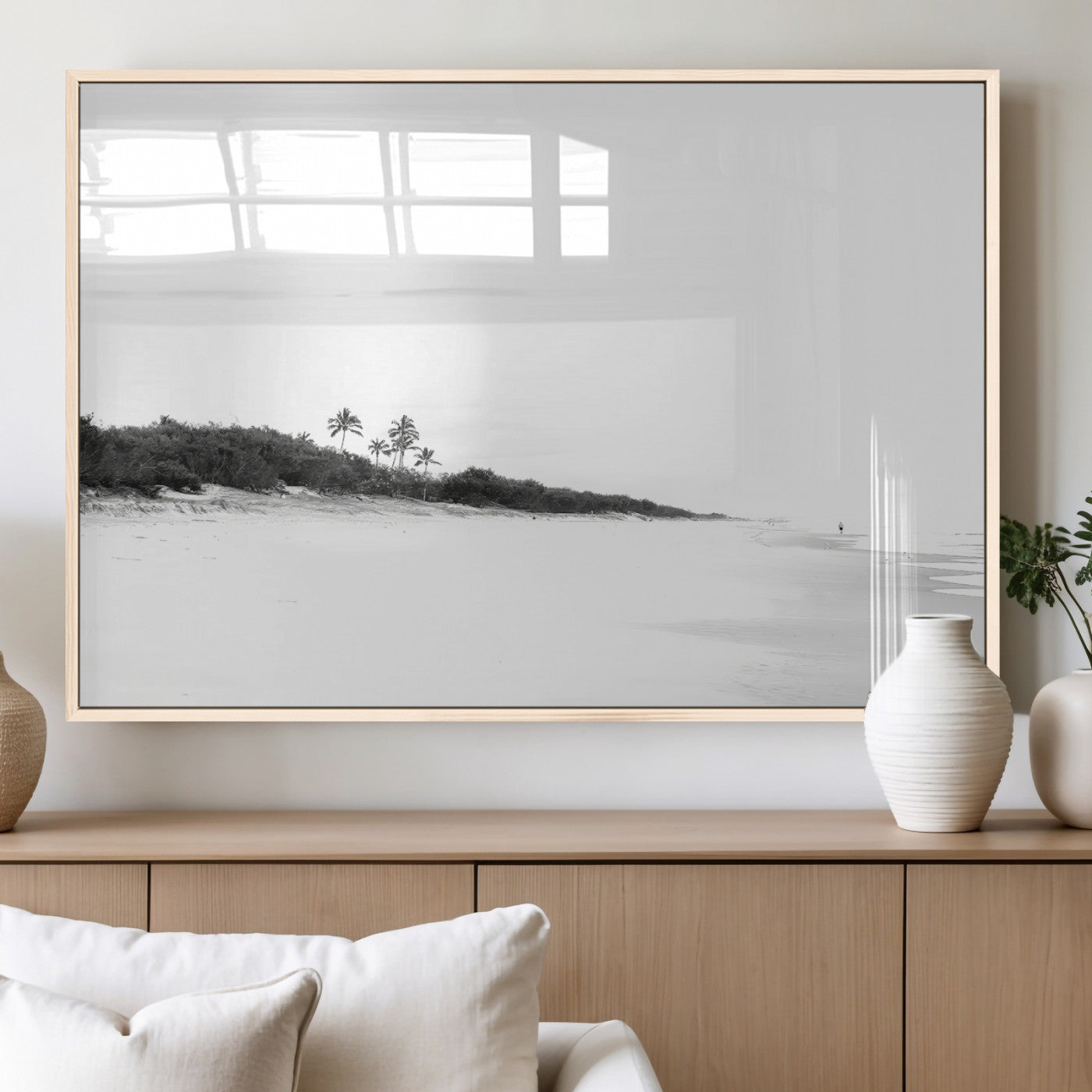 A black and white minimalist coastal scene with a vast open beach, distant palm trees, and a lone figure walking along the shoreline, evoking serenity and solitude.