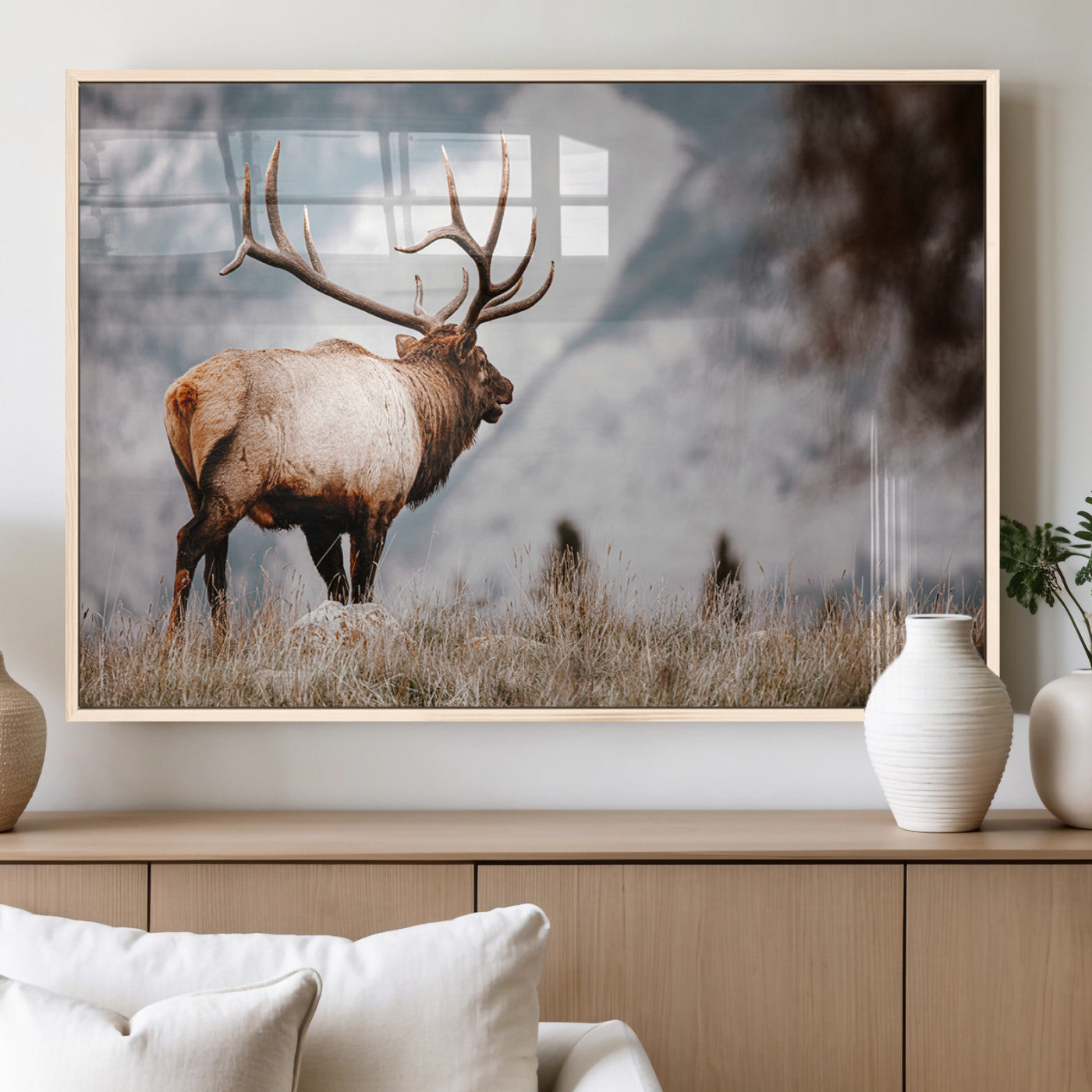 Majestic elk with large antlers standing in grass with snowy mountains in background, perfect for rustic cabin or lodge style decor.