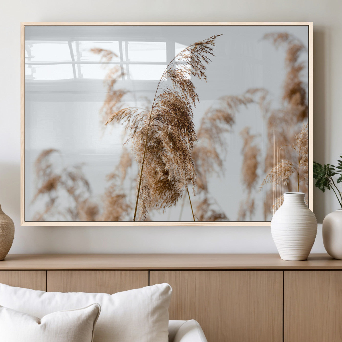 Close-up of pampas grass swaying in the wind against a soft white sky, creating a neutral and minimalist botanical aesthetic.